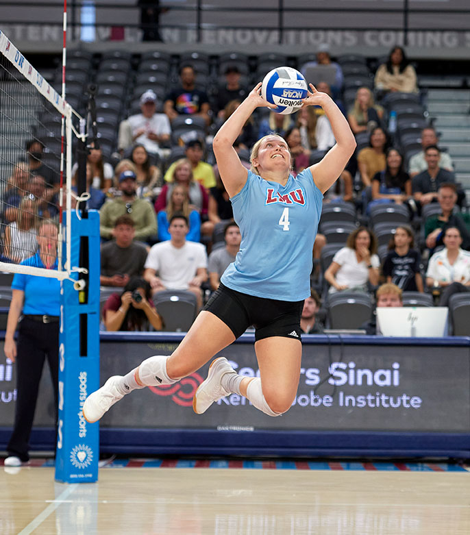 volleyball player jumping up and setting up ball
