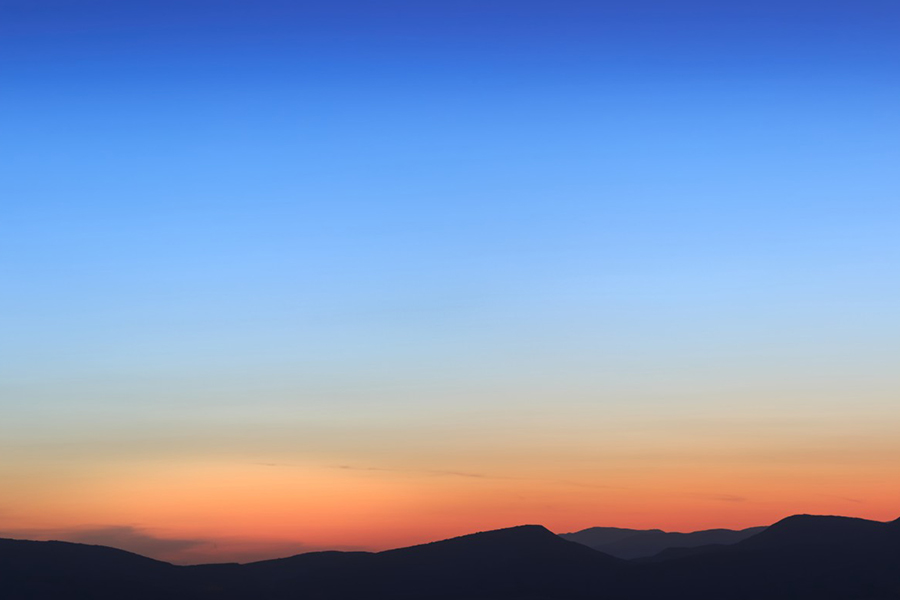 Blue and Orange Sky over dark mountains