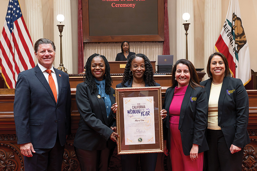 Members of the California Legislature pose with Kawanna Leggett holding a plaque for 
