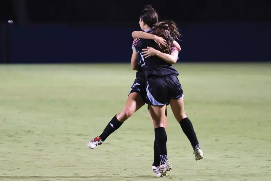 Two LMU Womens Soccer Players Hug after winning a game
