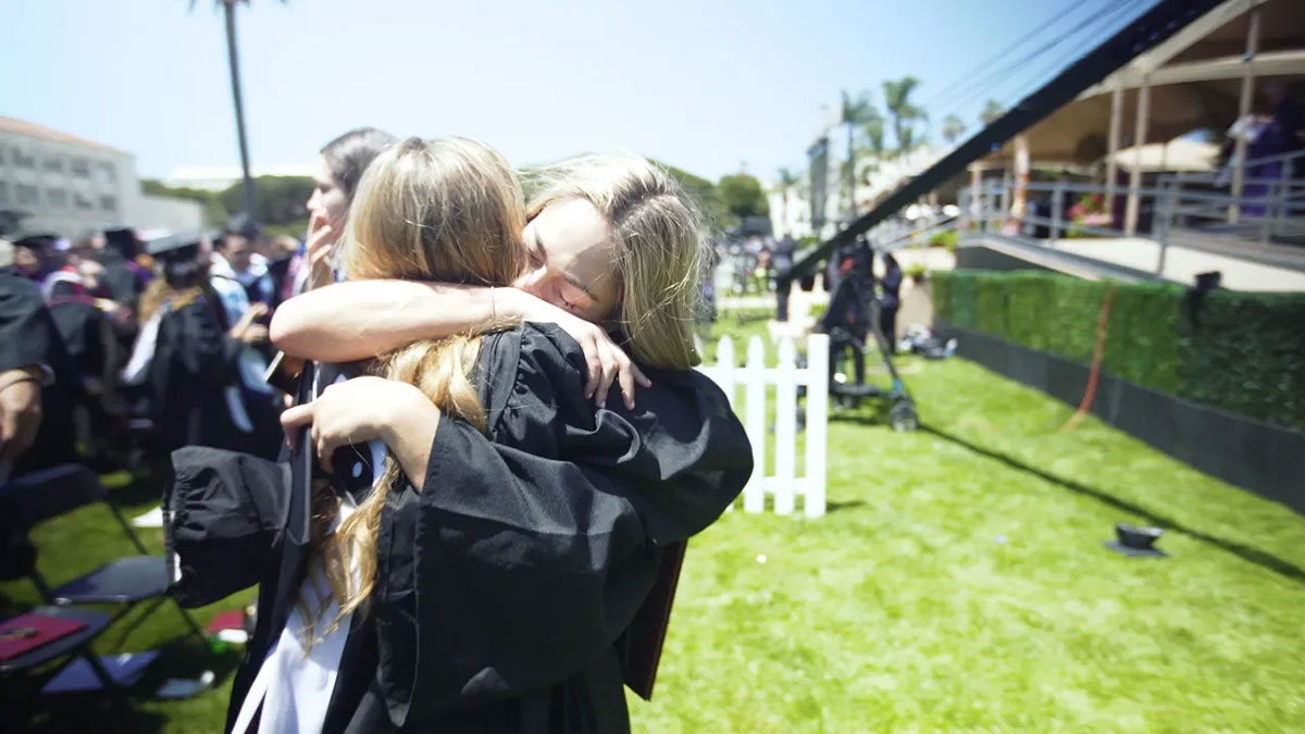 Two newly graduated students hugging upon the completion of Commencement