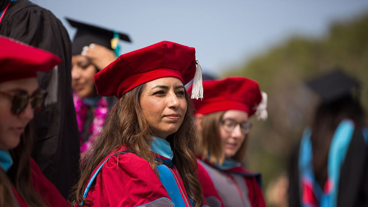 Graduate students seated and listening to commencement speakers
