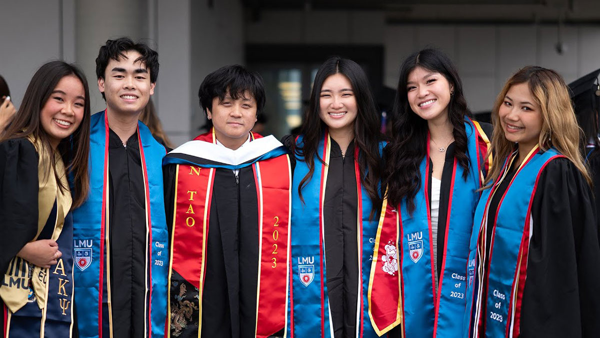Several graduates smiling outside of the event venue