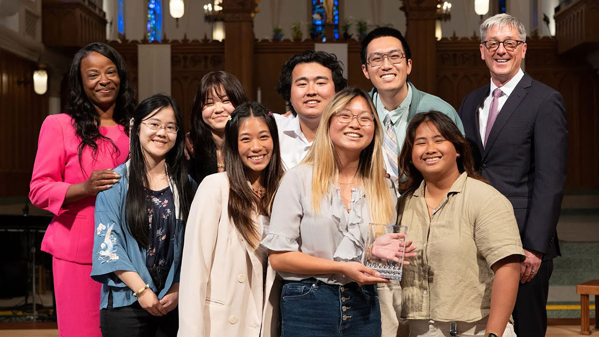 Several award winners standing on stage with Vice President Kawanna Leggett and President Timothy Law Snyder