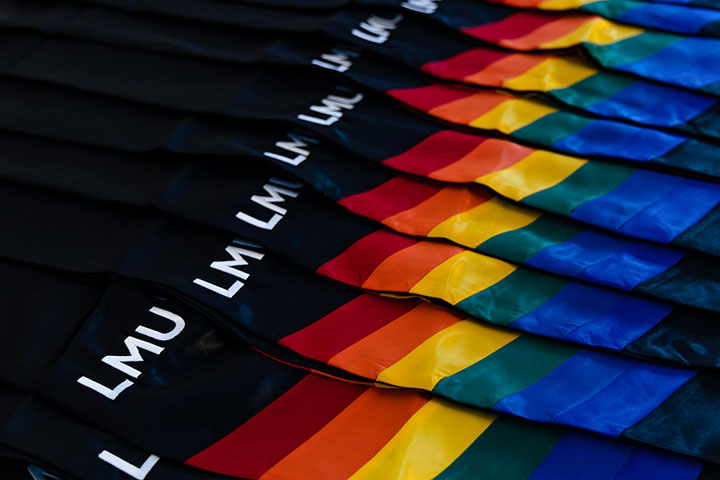 A series of multi-colored sashes laid across a table before being distributed to the graduates
