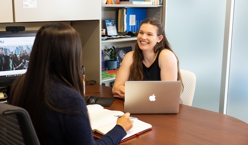 Student in staff's office sitting across from them and discussing resources on campus