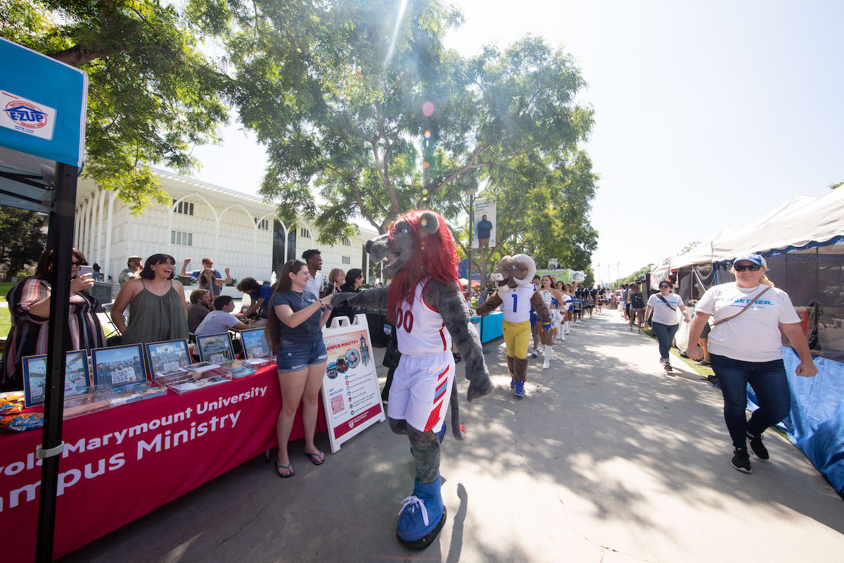 Iggy the Lion parades down alumni mall with the Rams cheerleaders and mascot