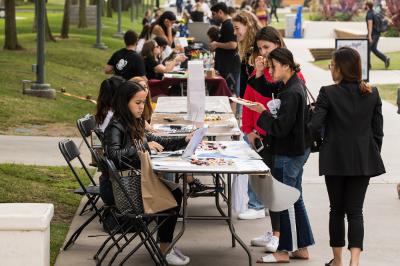 Students outside at a Student Involvement Fair meeting together.