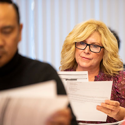 Female adult learner looking at papers in a class room